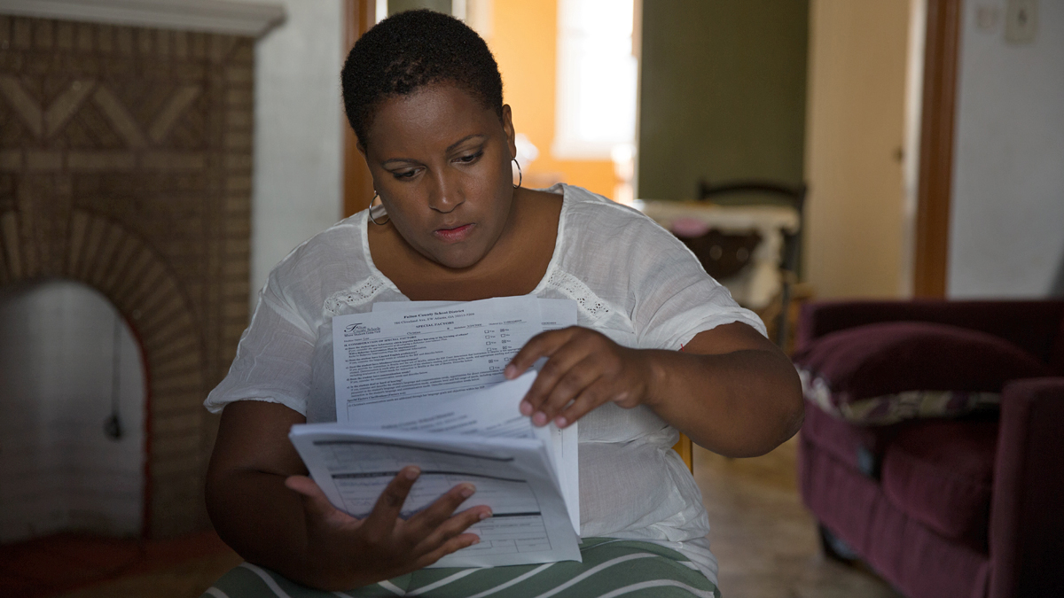  LaTonia Lee looks through her daughter's Individual Education Plan that was prepared in Georgia.  (Lindsay Lazarski/WHYY) 