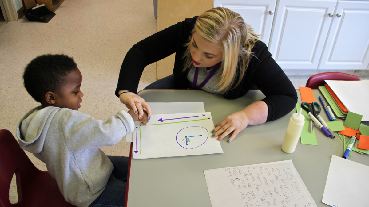  Pre-K teacher Danielle Slipp shows Quincy Hylaris how to make an L. (Emma Lee/WHYY) 