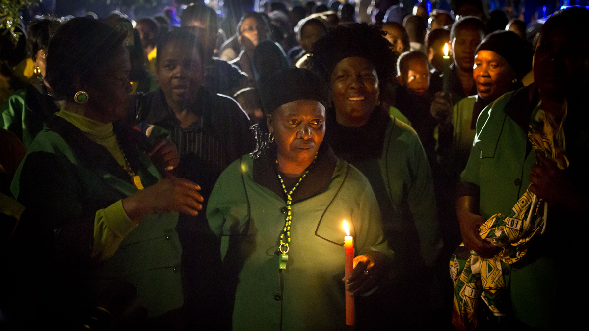  Members of the African National Congress Womens League hold candles and sings songs in memory of Nelson Mandela outside his old house in Soweto, Johannesburg, South Africa on Friday. (AP Photo/Ben Curtis) 