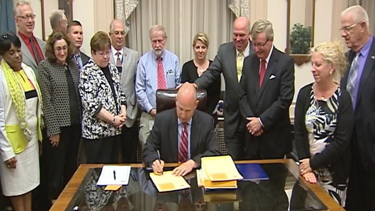  Lawmakers look on as Governor Markell signs bills early Tuesday morning. (Paul Parmelee/WHYY) 
