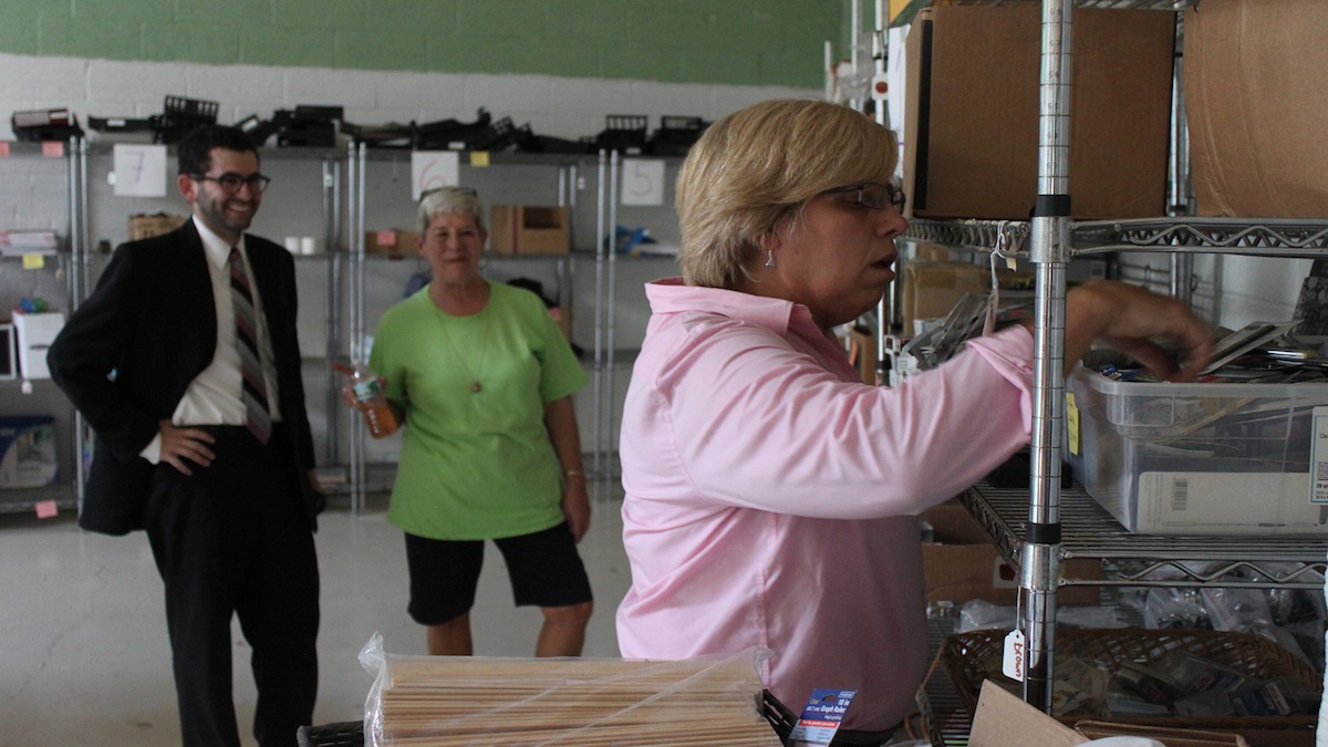 George Matysik and Steveanna Wynn look on while Principal Leslie Mason selects school supplies for Thomas Mifflin Elementary in East Falls. (Matthew Grady/for NewsWorks) 