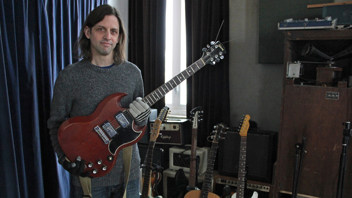 Brian McTear holds one of his favorite guitars. (Emma Lee/for NewsWorks)