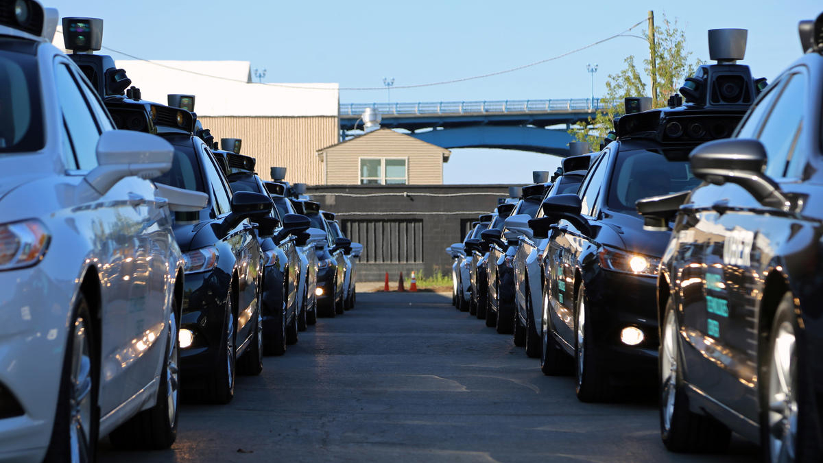 Uber technicians wait in the shadow of the company's new Advanced Technologies Center in Pittsburgh on Tuesday