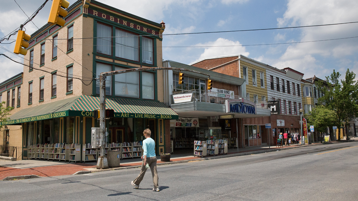  A woman crosses the street in Harrisburg’s Midtown neighborhood.  Harrisburg is the latest Pennsylvania municipality to partner with Nextdoor, a social networking site, designed to foster communication within a neighborhood and between city agencies and residents. (Lindsay Lazarski/WHYY) 