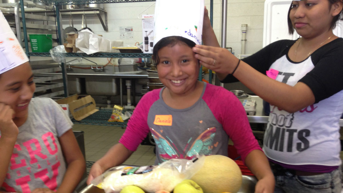  Daniela (center) poses with ingredients for her impromptu menu. (Avi Wolfman-Arent, NewsWorks) 