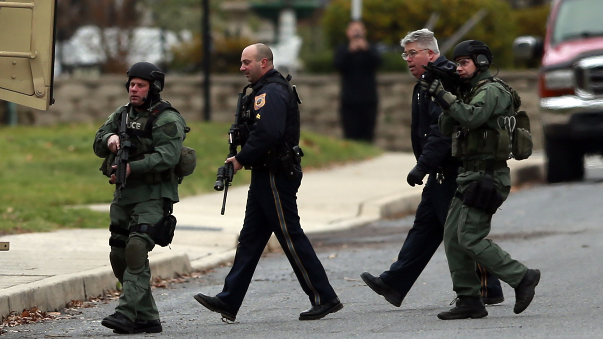 Police move near a home where a suspect is believed to have barricaded himself inside after shootings at multiple homes Monday, Dec. 15, 2014, in Souderton, Pa. Police tell WPVI-TV the man is suspected of killing a five people Monday morning at three different homes northwest of Philadelphia. (AP Photo/Matt Rourke)
