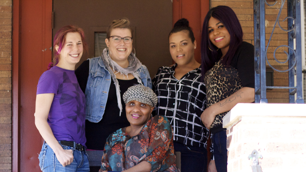  Residents and staff on the porch of the Morris Home, located in Southwest Philadelphia. From left are Kai; Program Director Laura Sorensen; Nikki; Lauren; and Barbie, center. (Kyrie Greenberg/for NewsWorks) 