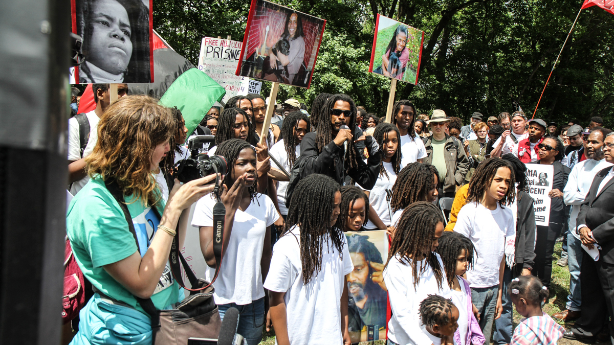 Members of MOVE speak out a rally commemorating 30 years since the bombing of a West Philadelphia block in which eleven people died. (Kimberly Paynter/WHYY)