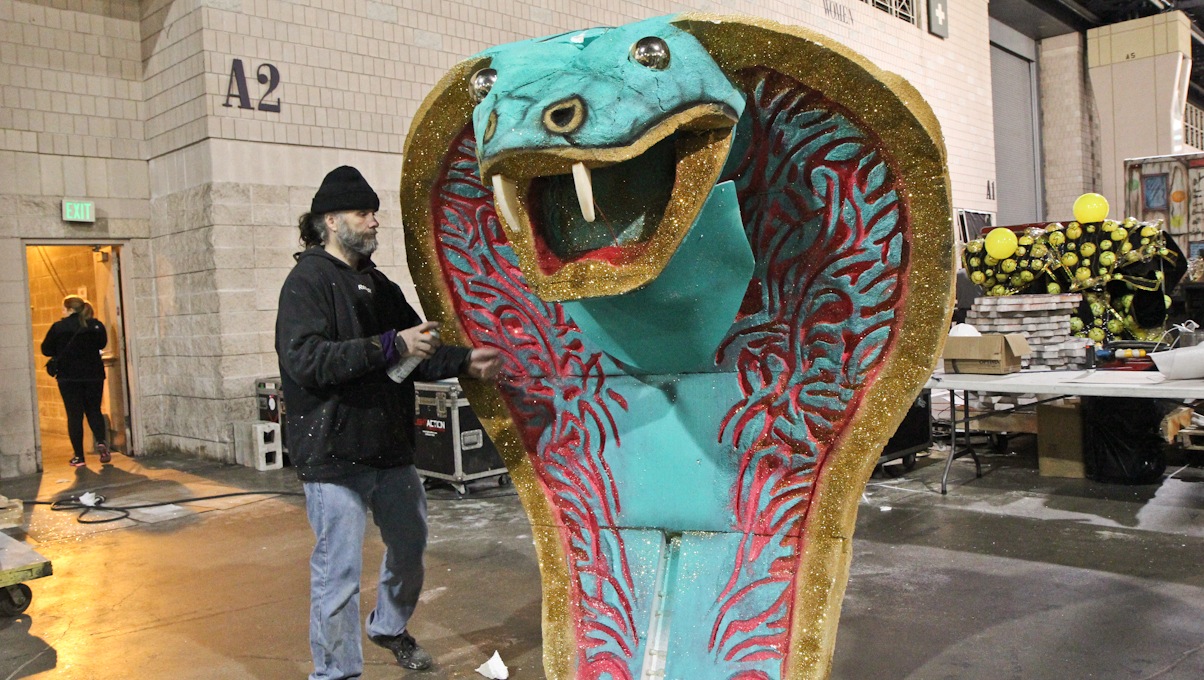  Six-year Mummer Chris Hillman of Golden Crown puts the finishing touches on a hypnotizing foam snake. (Kimberly Paynter/WHYY) 