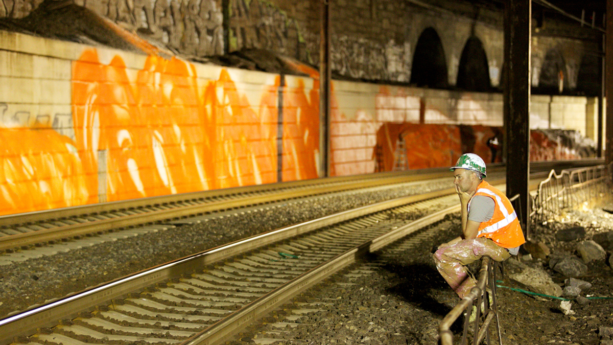  German artist Arne Schreiber observes progress to a major public art installation along the rail tracks outside of 30th Street Station and the Schuylkill Expressway in Philadelphia, Pa.  (Nathaniel Hamilton/For NewsWorks)  