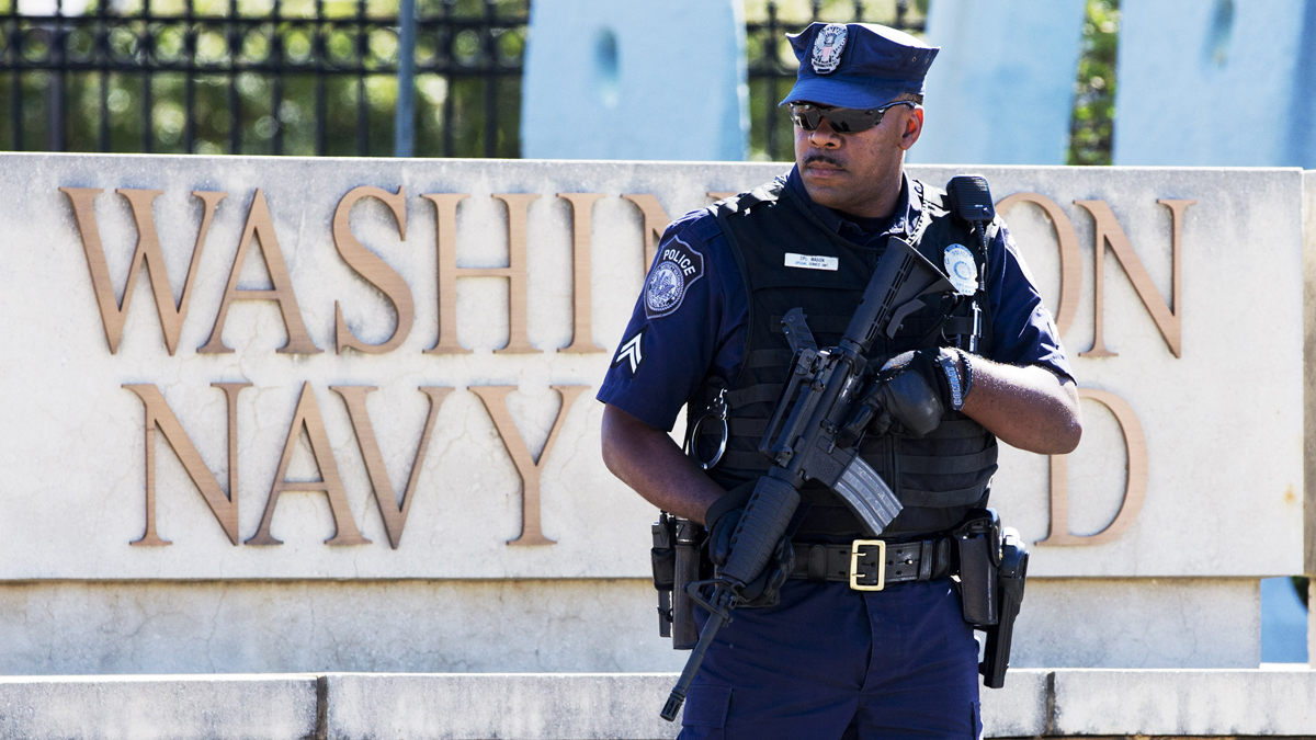  An armed officer works near the gate at the Washington Navy Yard, closed to all but essential personnel, on Tuesday, Sept. 17, the day after a gunman launched an attack inside. (AP Photo/Jacquelyn Martin) 