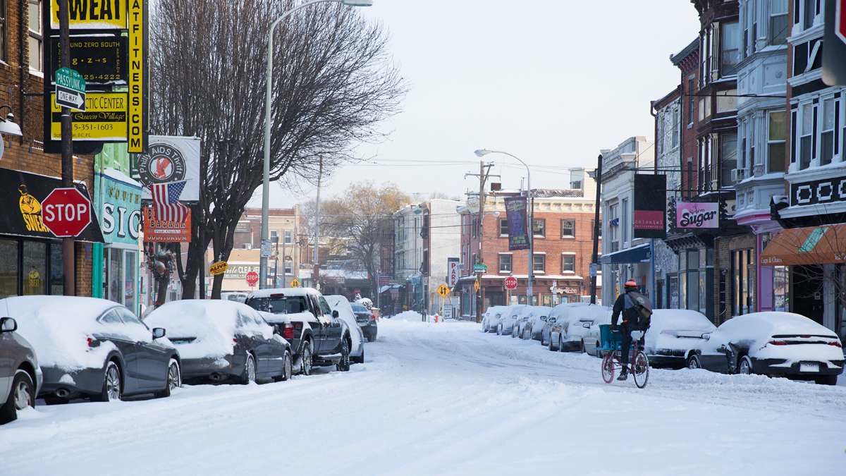  A cyclist bikes through the Queen Village neighborhood of Philadelphia after six to 10 inches of snow fell overnight. (Lindsay Lazarski/WHYY) 
