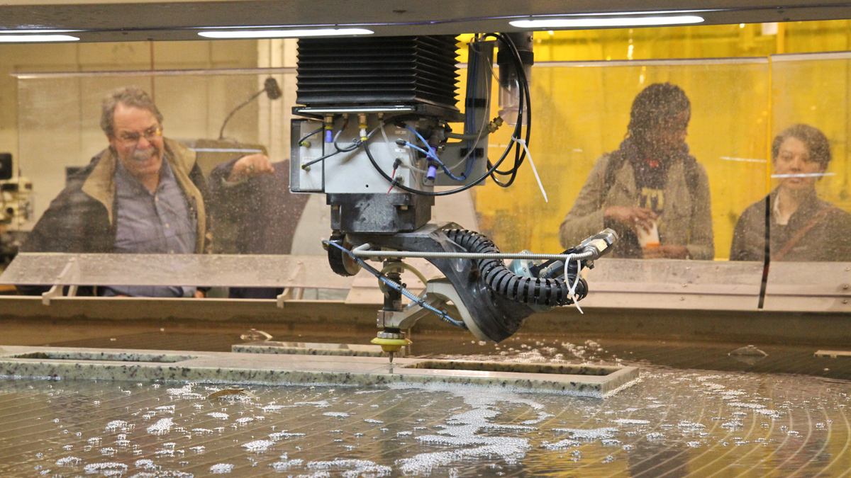  Observers check out the waterjet cutting machine demonstration at NextFab Studio in Philadelphia. (Kimberly Paynter/WHYY) 