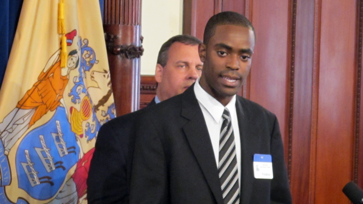  As N.J. Gov. Chris Christie looks on, Jarred Phillips explains why he's participating in the Woodrow Wilson New Jersey Teaching Fellows program. (Phil Gregory/WHYY) 