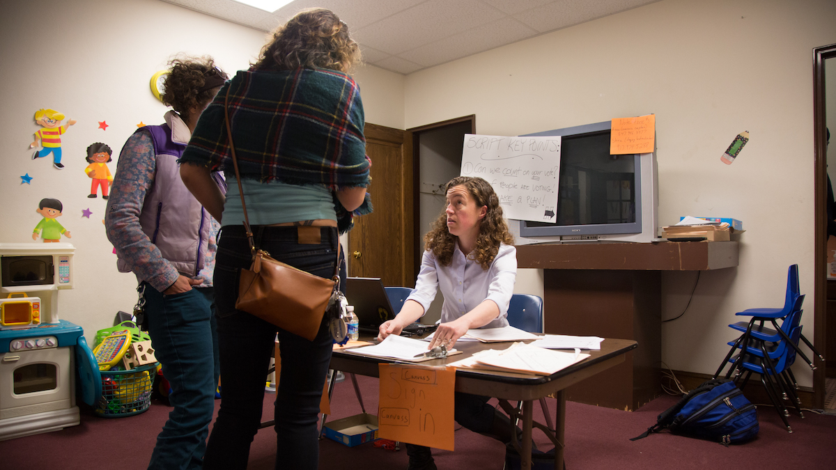 Hillary for President volunteer, Michelle Dorothy, from Virginia, checks in new canvasers before sending them to a quick training at a Get Out The Vote center in North Philadelphia. (Emily Cohen for NewsWorks)