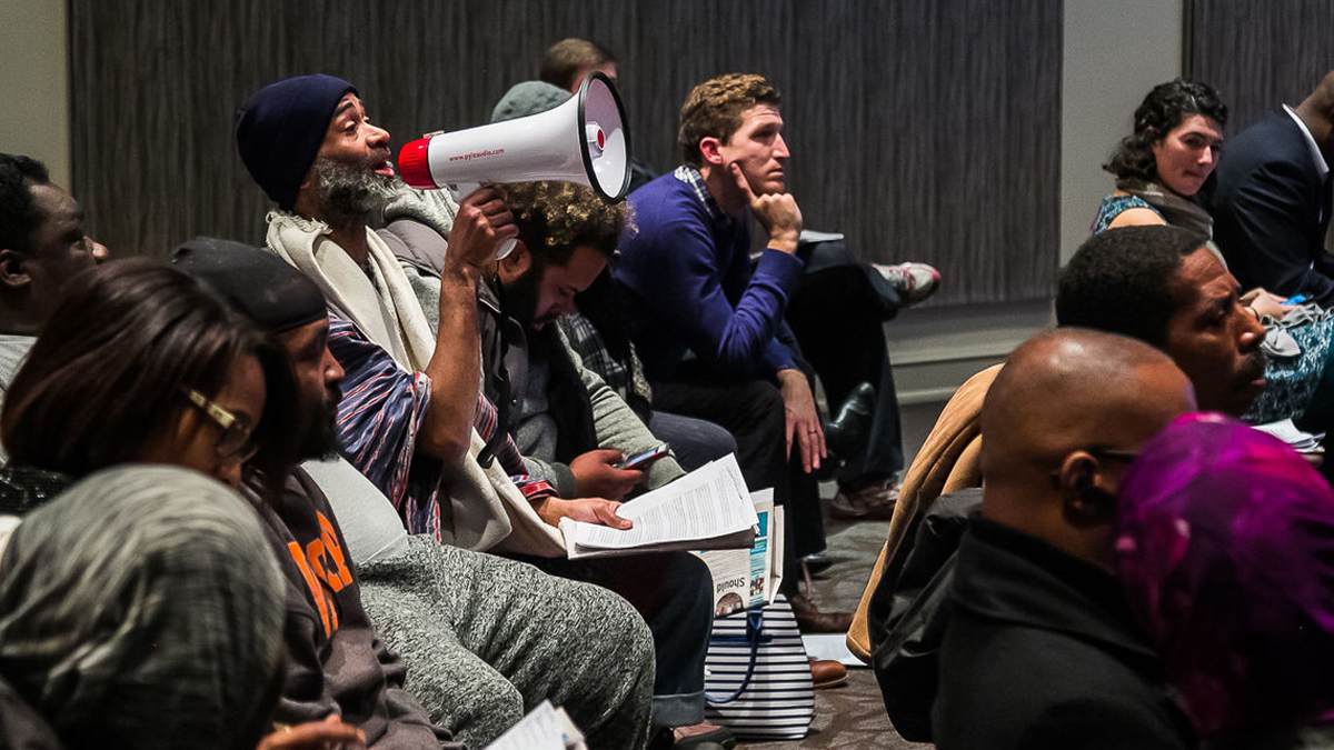 A protester disrupts the school governance forum calling on the District to improve poor conditions in public schools. (Darryl Murphy/The Notebook)