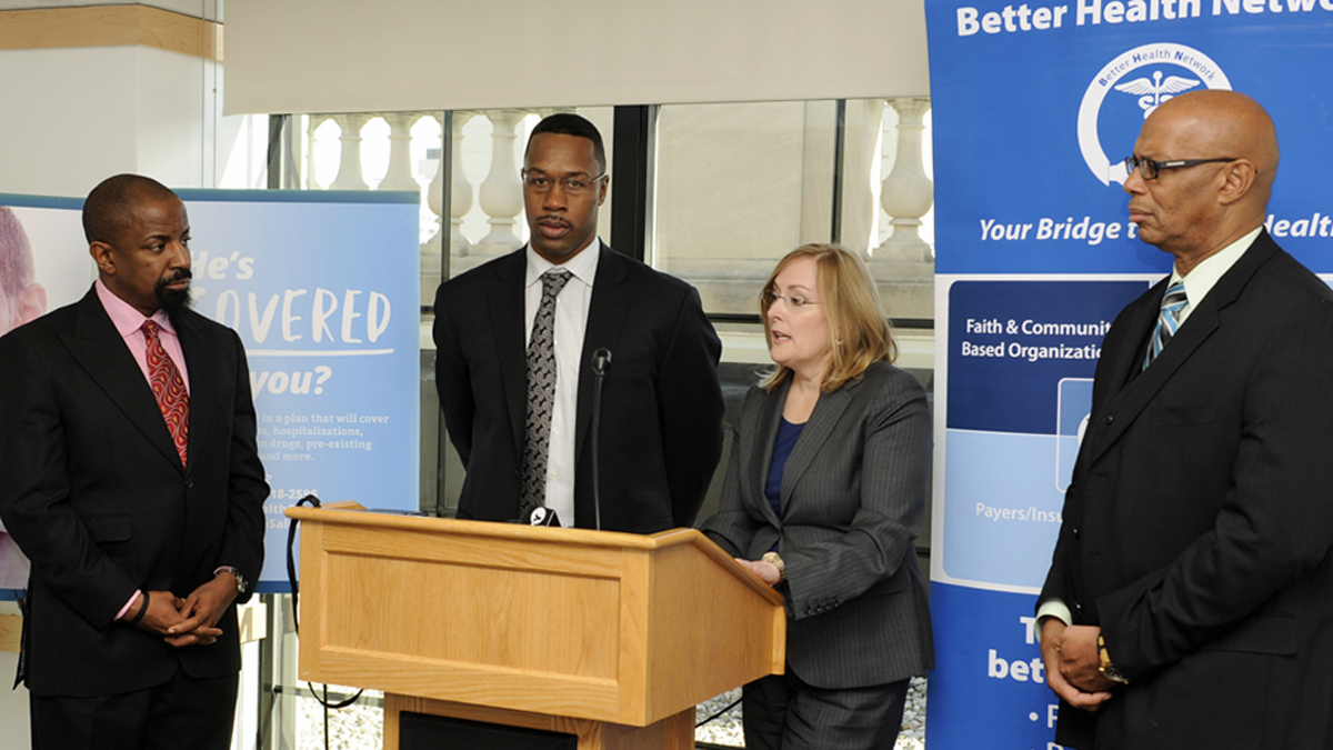  Reverend Lonnie Herndon (left), and Jermaine Bromell (center), listen to Nancy O'Connor. Dr. Garth Gittens listens at right. (Jonathan Wilson/for NewsWorks) 