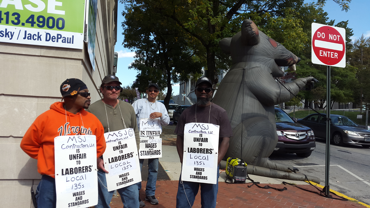  Protesters outside of 9 W. Main St. in Norristown, Pa. Efforts to fix up the historic PNC building have attracted scrutiny from labor, town officials and the press. (Laura Benshoff/WHYY) 