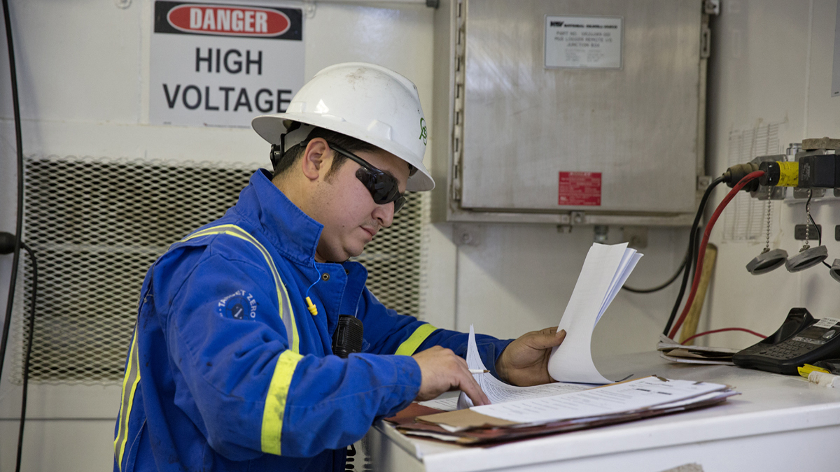  A worker checks paperwork on the monkey board of a Cabot Oil & Gas drill rig in Kingsley, Pa.  (Lindsay Lazarski/WHYY)   