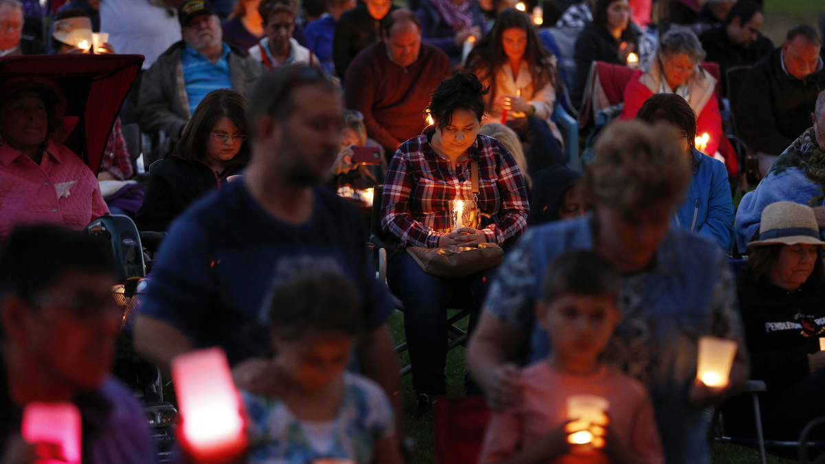  People bow their heads in prayer during a prayer vigil Saturday, Oct. 3, 2015, in Winston, Ore. The vigil was held in honor of the victims of the fatal shooting at Umpqua Community College on Thursday. (AP Photo/John Locher) 
