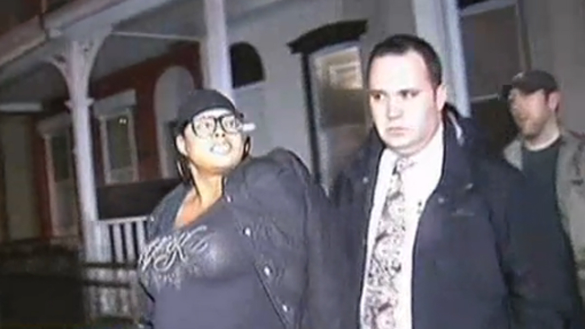 Police Lt. John Walker leads Padge Windslowe away from a buttocks-injection 'pumping party' in Germantown in 2012. (Courtesy of NBC10)
