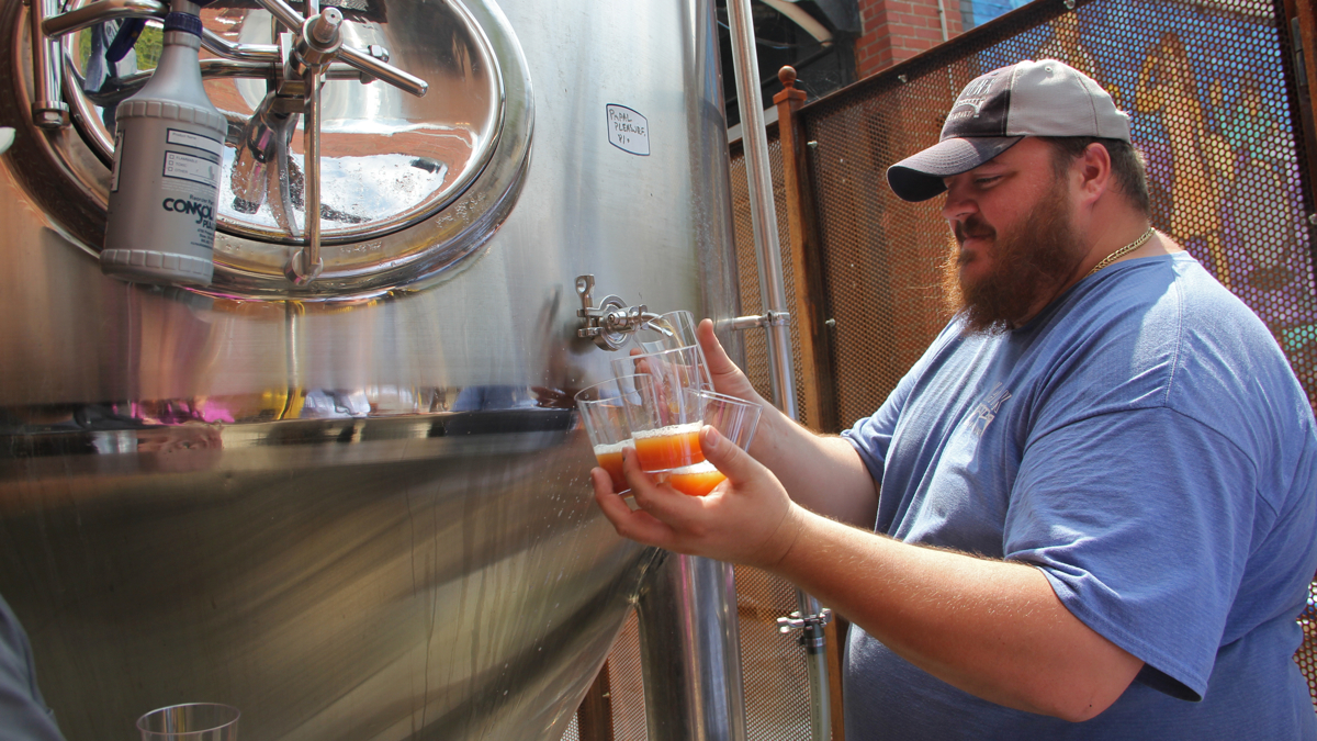  Evan Fritz, head brewer at Manayunk Brewing Company, draws off some samples of Papal Pleasure, a beer concocted to mark Pope Francis' visit to Philadelphia. (Emma Lee/WHYY 