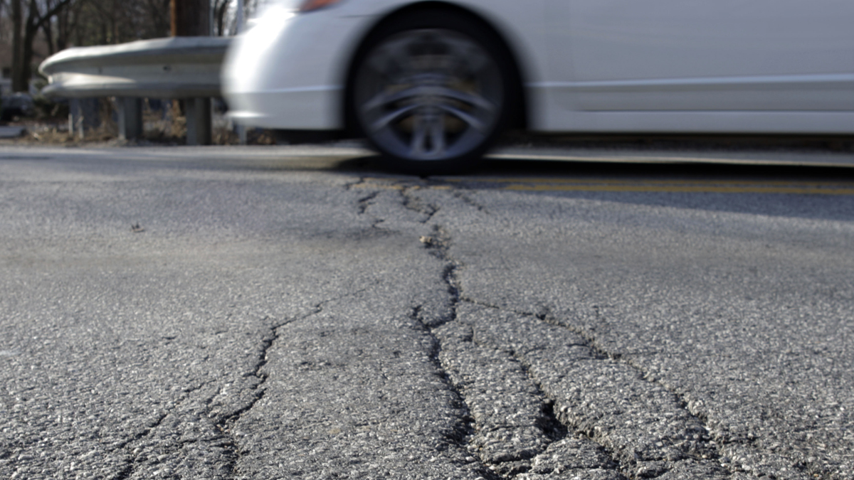 A car drives over crumbling pavement in Carlisle, Pa.  (AP File Photo/Carolyn Kaster) 