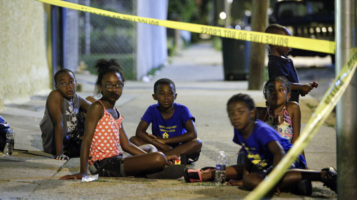  Children from Treana's Little Castle Learning Center watch police officers as they investigate a crime scene in the East Mount Airy section of Philadelphia on Friday July 27, 2012. (Photography by Joseph Kaczmarek, courtesy of GunCrisis.org)  