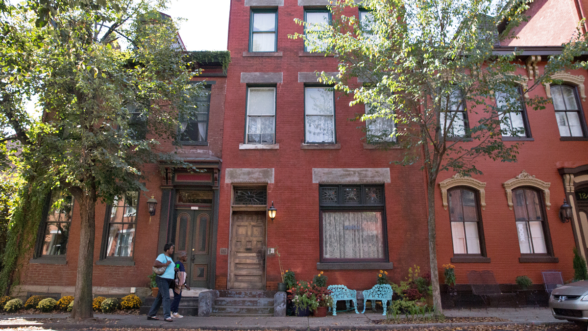  Two women walk down a street in Pittsburgh’s historic Mexican War Streets district.  (Lindsay Lazarski/WHYY)  