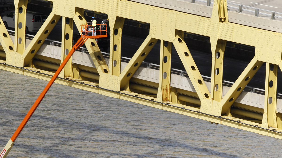  Workers are lifted beside the superstructure on the Ft. Pitt Bridge over the Monongahela River in Pittsburgh.. (AP Photo/Keith Srakocic) 