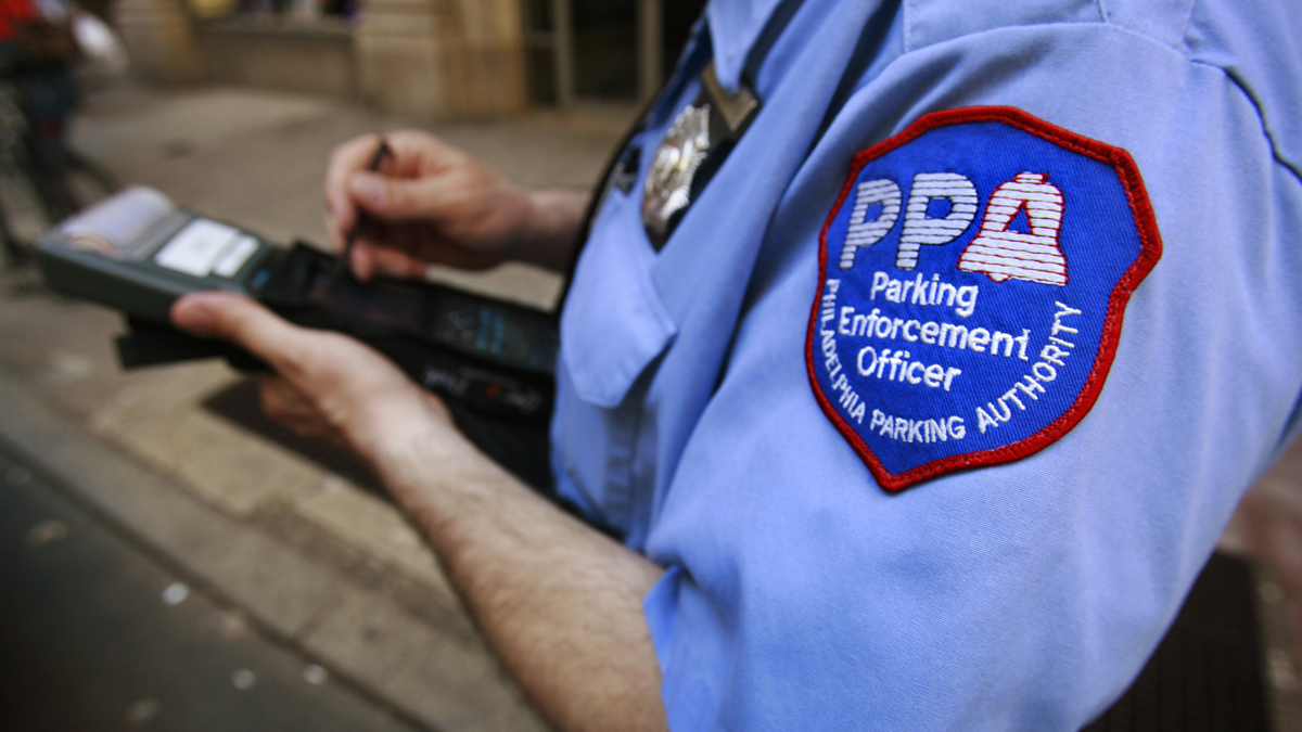 A member of the Philadelphia Parking Authority writes a ticket for an expired meter in Center City.