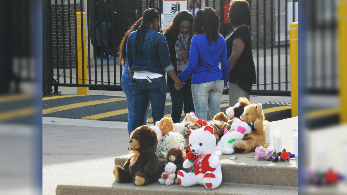 Staff and parents gathered in prayer near a makeshift memorial honoring Joyner-Francis outside Howard High on Friday morning. (John Jankowski/for NewsWorks)