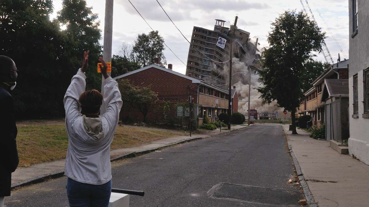 City Councilwoman Cindy Bass applauds after pushing the 'detonator' that sent the Queen Lane Apartment demolition in motion on Saturday. (Bas Slabbers/for NewsWorks)