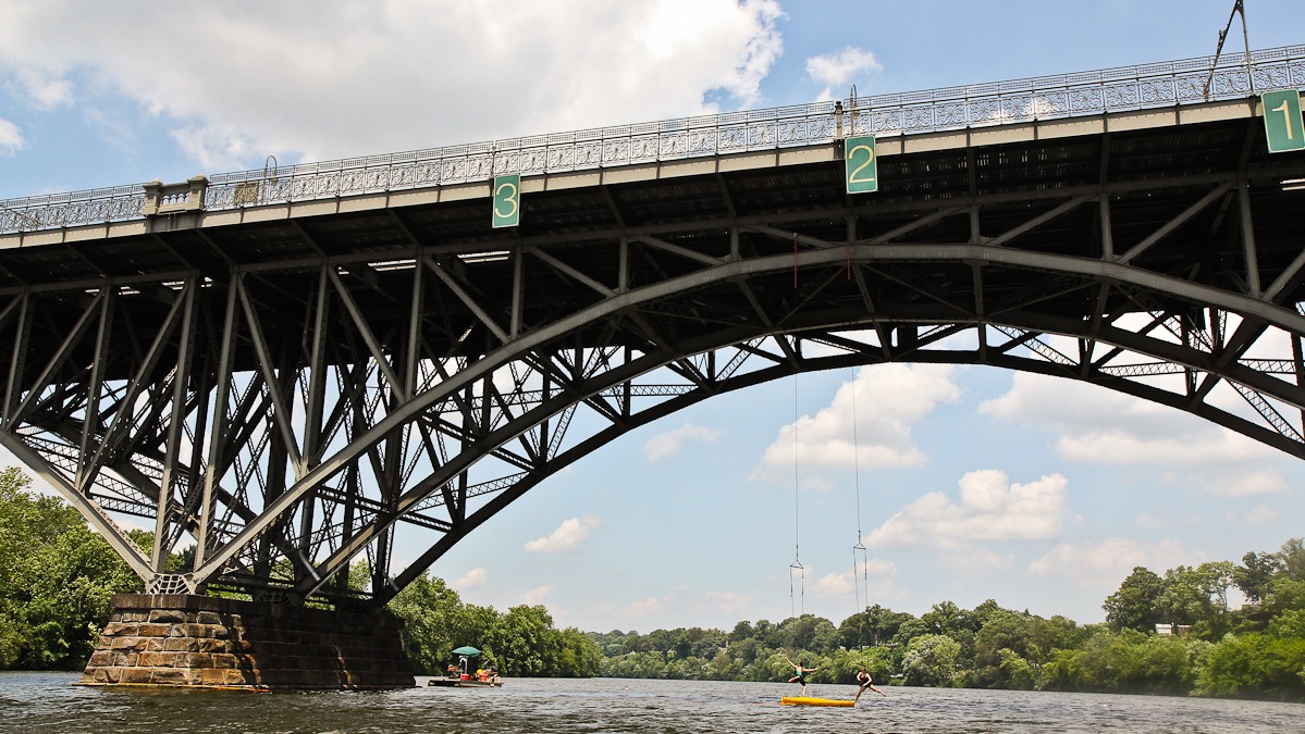 Dancers Amy Lynn Barr and Alie Vidich rehearse their aerial river performance beneath the Strawberry Mansion Bridge off of Kelly Drive. (Kimberly Paynter/WHYY) 
