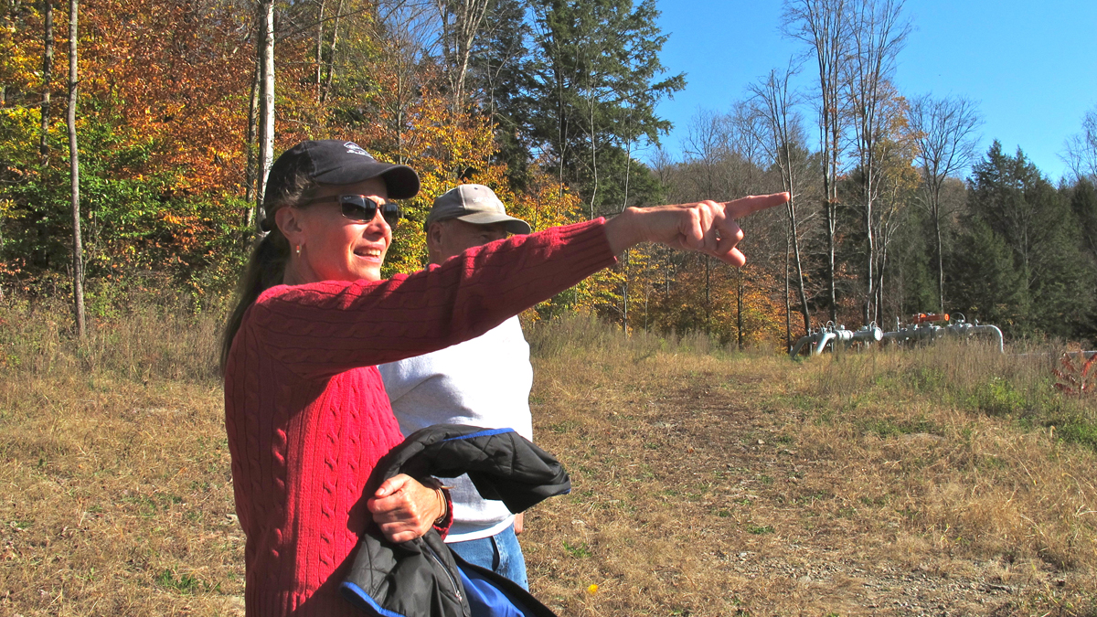  Neighbors Victoria Switzer and Ron Teel point to a natural gas compressor station on Teel's property in Dimock, Susquehanna County (Katie Colaneri/for NewsWorks) 