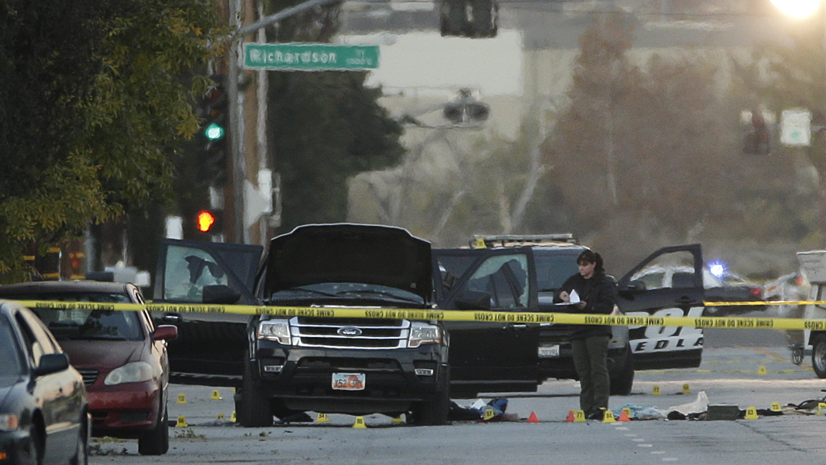  An investigator looks at a black SUV that was involved in a police shootout with suspects, Thursday, Dec. 3, 2015, in San Bernardino, Calif. A heavily armed man and woman opened fire Wednesday on a holiday banquet, killing multiple people and seriously wounding others in a precision assault, authorities said. Hours later, they died in a shootout with police.  (AP Photo/Jae C. Hong) 