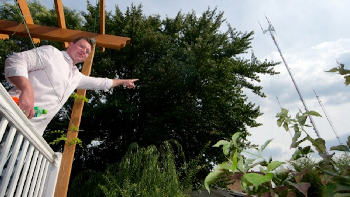  Standing on his Roxborough deck, Shane Brody points to the radio antennas that have him hearing voices. (Bas Slabbers/for NewsWorks) 