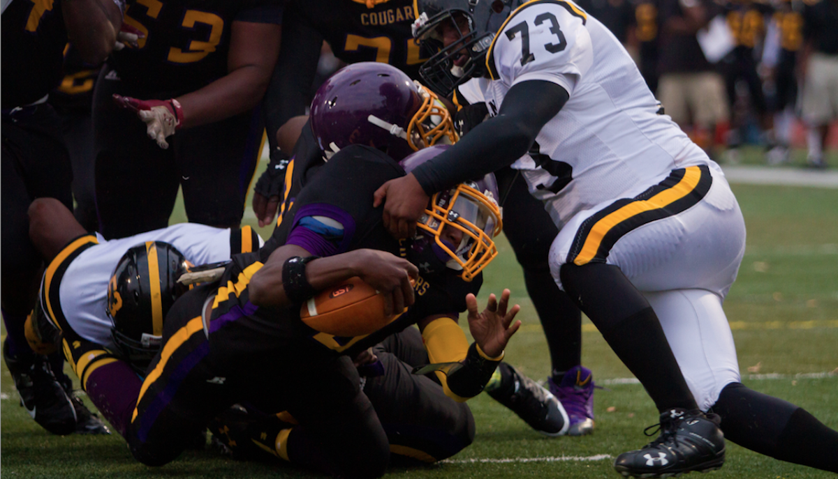 MLK quarterback Joseph Walker fights his way into the end zone Friday against Lincoln High. Walker had three touchdowns in the Cougars 34-6 victory. (Brad Larrison/for NewsWorks) 