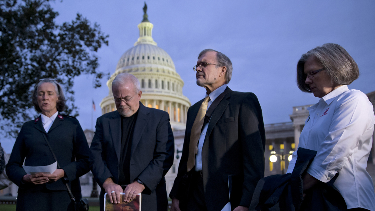  With time growing desperately short for Congress to prevent a threatened Treasury default and stop a partial government shutdown, a group of ministers, the Circle of Protection, pray at dawn at the Capitol to draw attention to lawmakers that political divisiveness hurts the most vulnerable Americans, in Washington, Tuesday, Oct. 15, 2013. From right: Kathy Saile, Gary Cook, Rev. Jim Wallis, and Major Carole Busroe of the Salvation Army. (AP Photo/J. Scott Applewhite) 