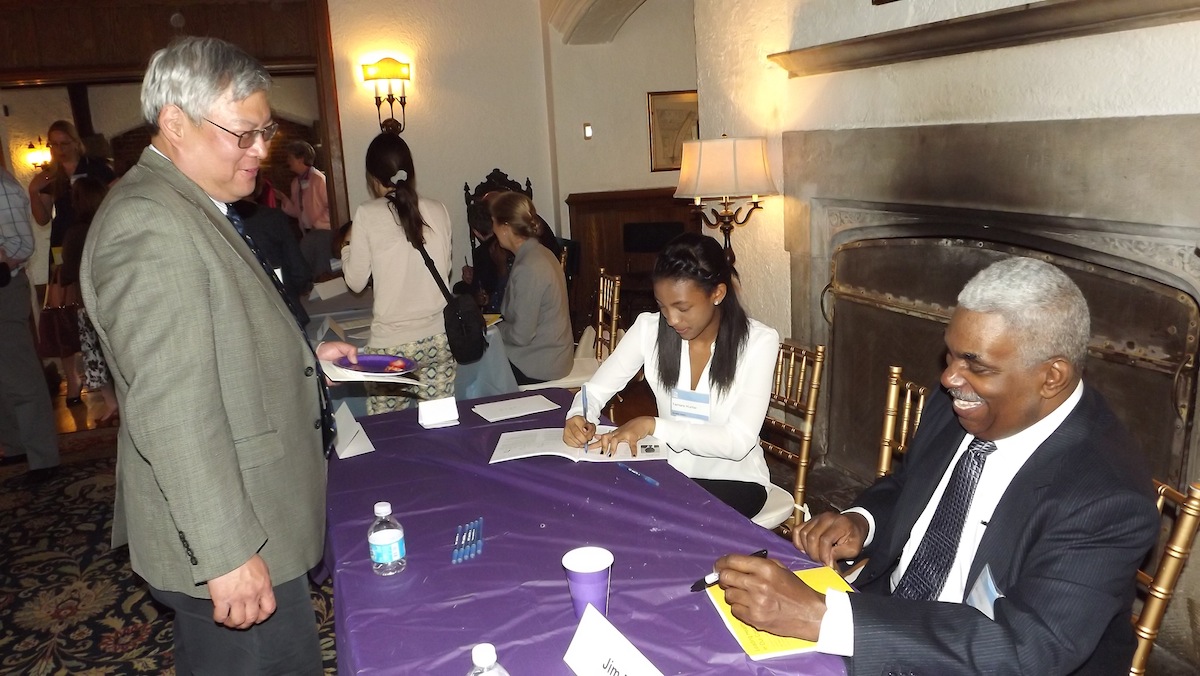 A student writer  and interviewee Jim Ellis sign a  copy of the book. (J. Woods/Newsworks)