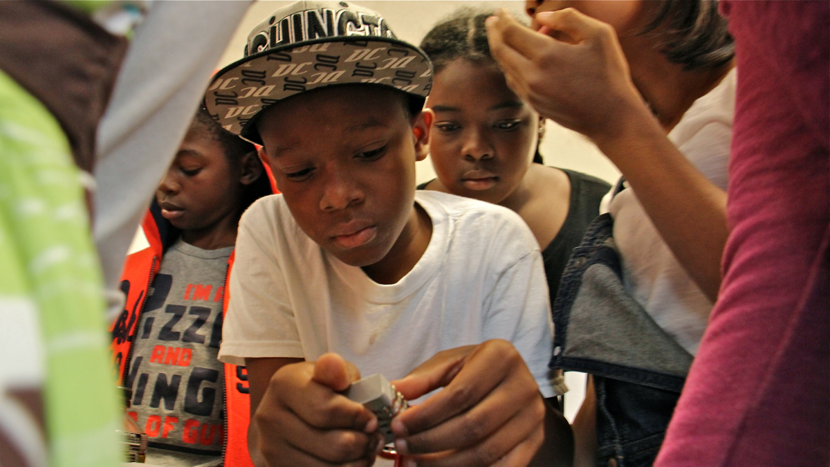 Students at Science Leadership Academy Middle School use clues to figure out how to open a locked box in their classfoom. (Emma Lee/WHYY)