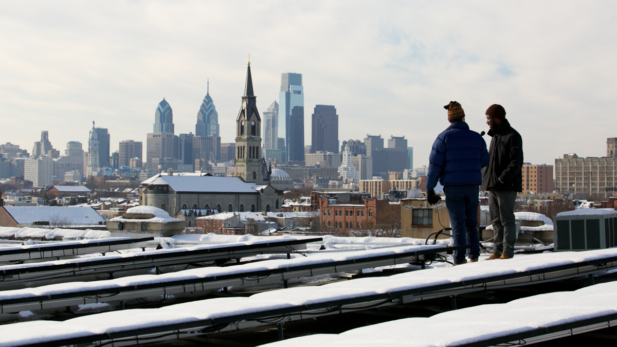  WHYY reporter Zack Seward interviews James Bailey of Solar States on top of the Crane Arts Building. (Nathaniel Hamilton/for Newsworks) 