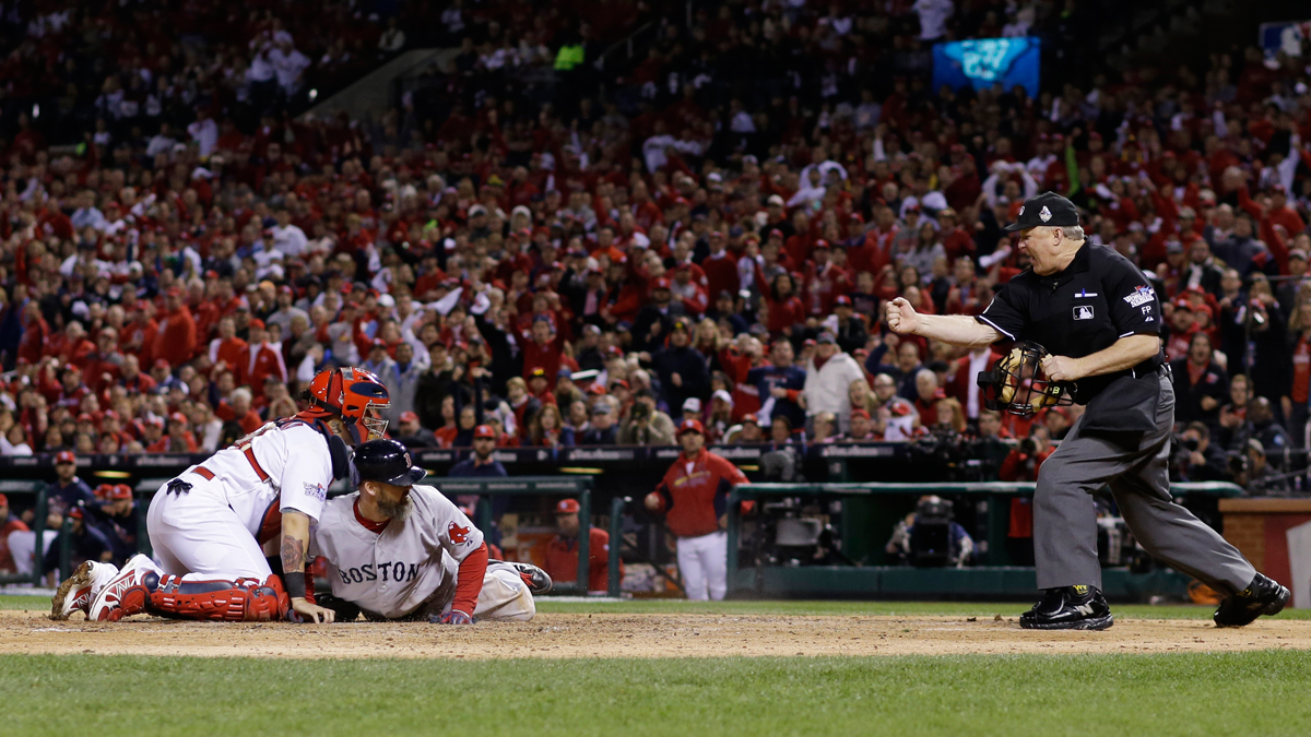 Home plate umpire Bill Miller makes the call as Boston Red Sox David Ross tags out St. Louis Cardinals catcher Yadier Molina as he tries to score from second on a single by Jacoby Ellsbury during the seventh inning of Game 5 of baseball's World Series Monday