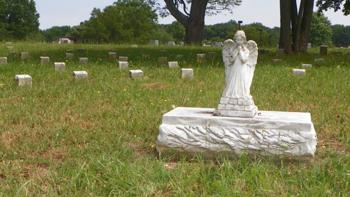  Stones marked with only numbers surround this sculpted angel at the cemetery on the DHSS campus near New Castle. (photo courtesy DCRC) 