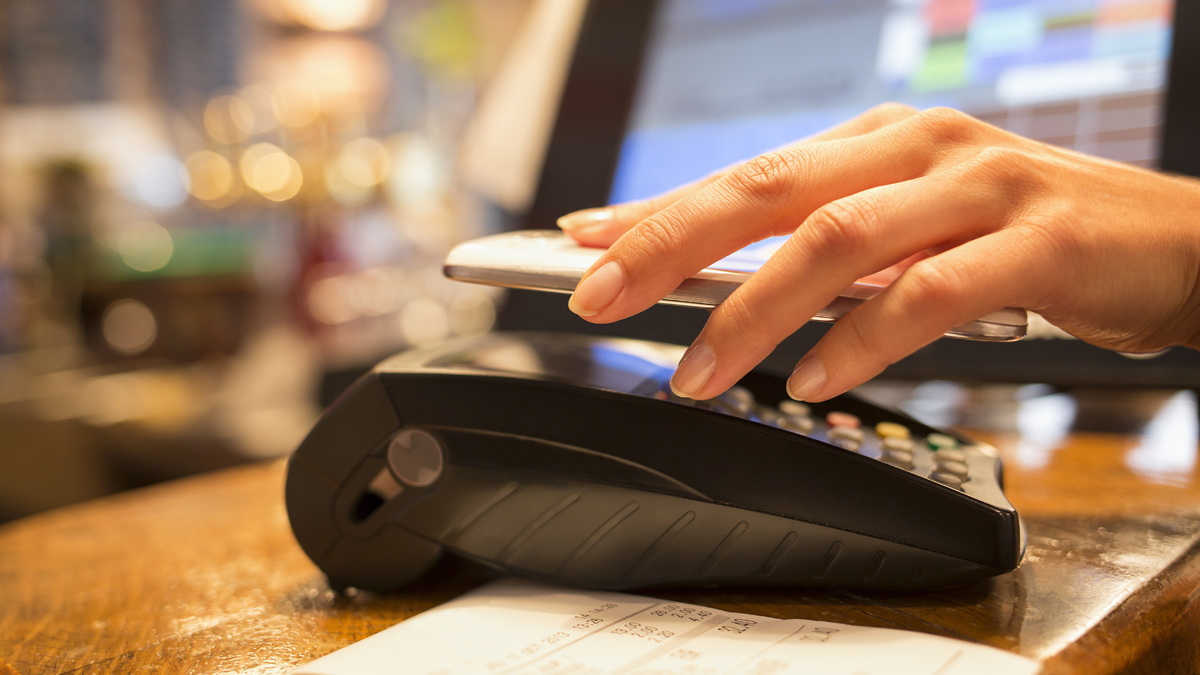  (<a href=“http://www.shutterstock.com/pic-159873416/stock-photo-woman-paying-with-nfc-technology-on-mobile-phone-restaurant-cafe-bar.html?src=EeFsULf7rfnc-NHDajgzxA-1-1”>Photo</a> via ShutterStock) 