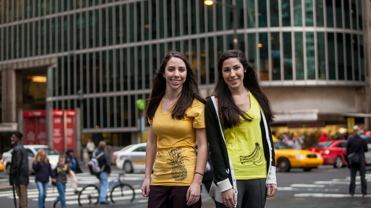  Twins Rachel and Sarah Stanton are shown wearing two of their Fruitstrology shirts. (Brad Larrison/for NewsWorks) 