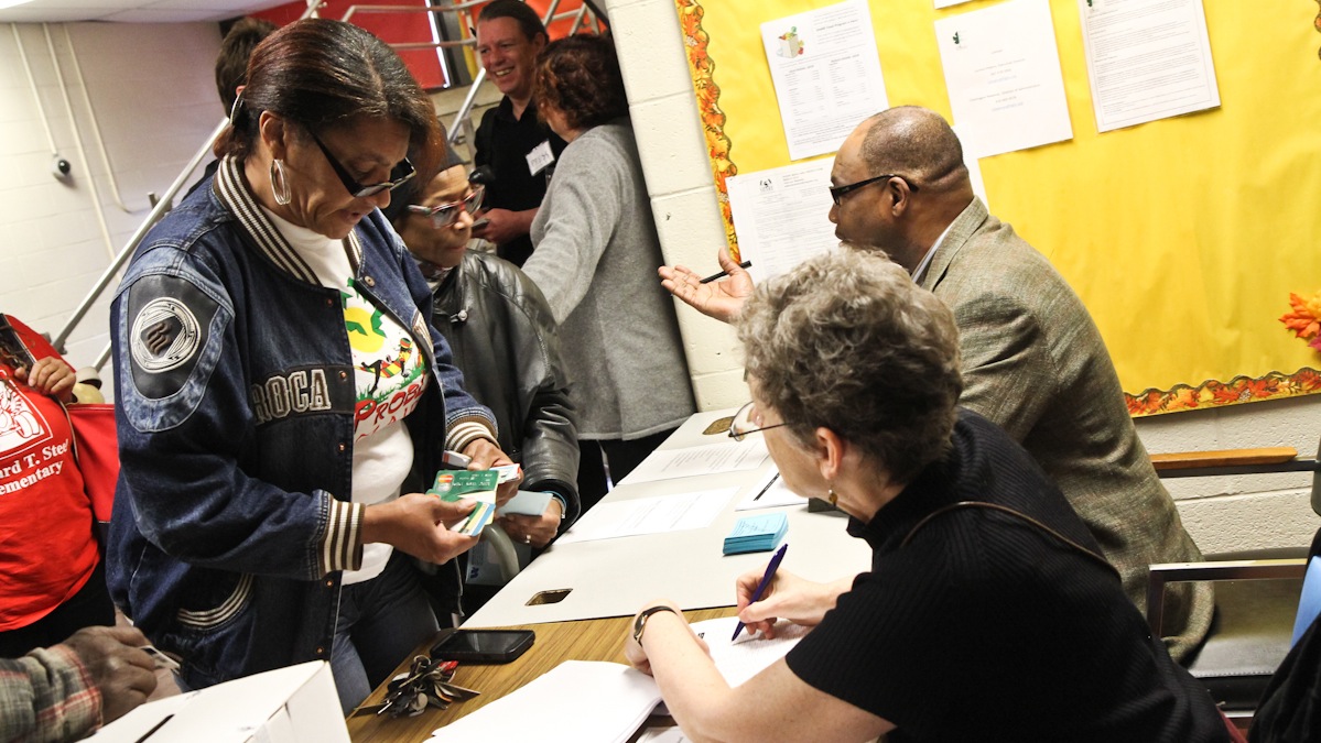  Fatima Byrd has a son at Steel and presents identification to be able to vote to keep the school public. (Kimberly Paynter/WHYY) 