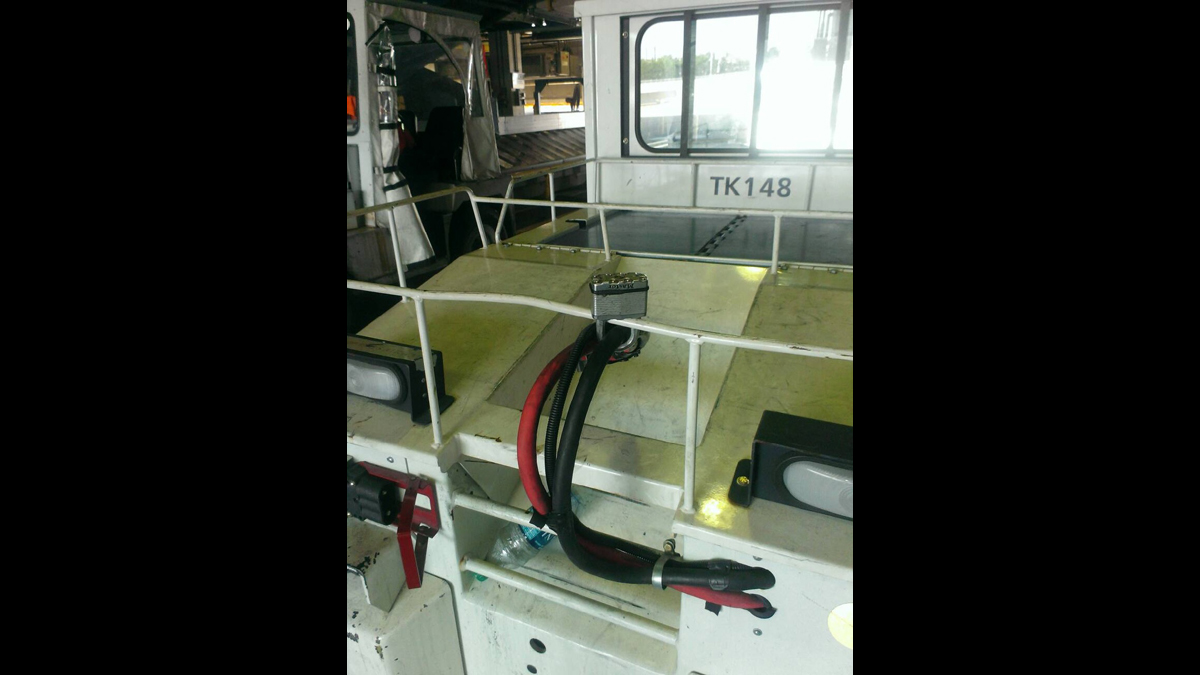  Airport workers allege that their white colleagues use padlocks - like the one on this tug's electrical cables -  to disable the best equipment and reserve it for white workers' use. (Image courtesy of attorney Brian Mildenberg) 