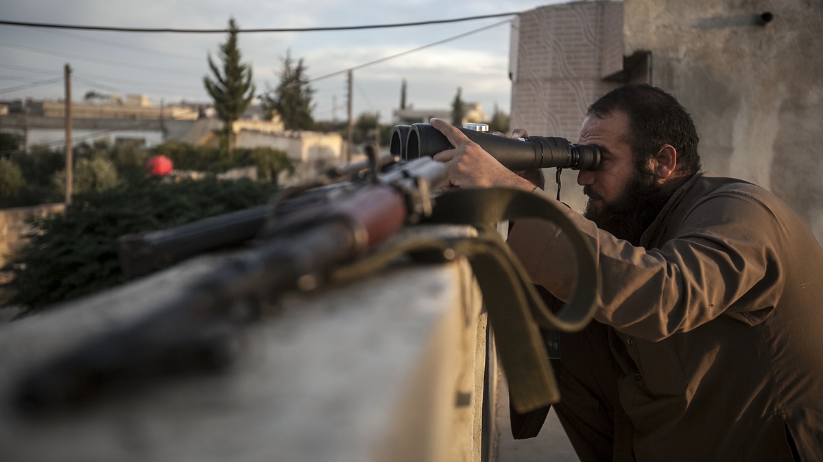  A Syrian opposition fighter watches over as heavy fighting sparks out in the neighboring village of Kafr Nabuda in the Idlib province countryside, Syria, Thursday, Sept. 19, 2013.  (AP Photo) 