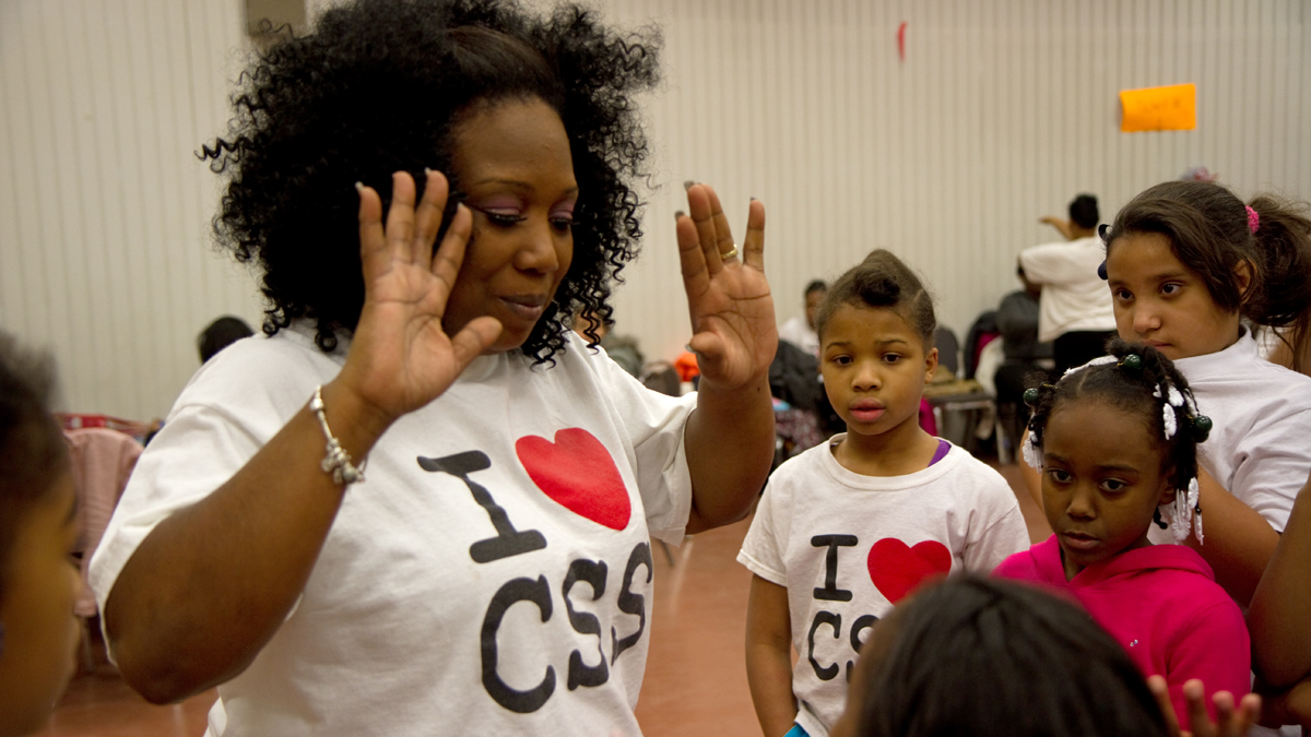  Camden Sophisticated Sisters' leader Tawanda Jones gives high fives to members of the step team.  (Lindsay Lazarski/WHYY, file) 
